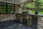 Large gas grill and outdoor kitchenette area with beverage fridge